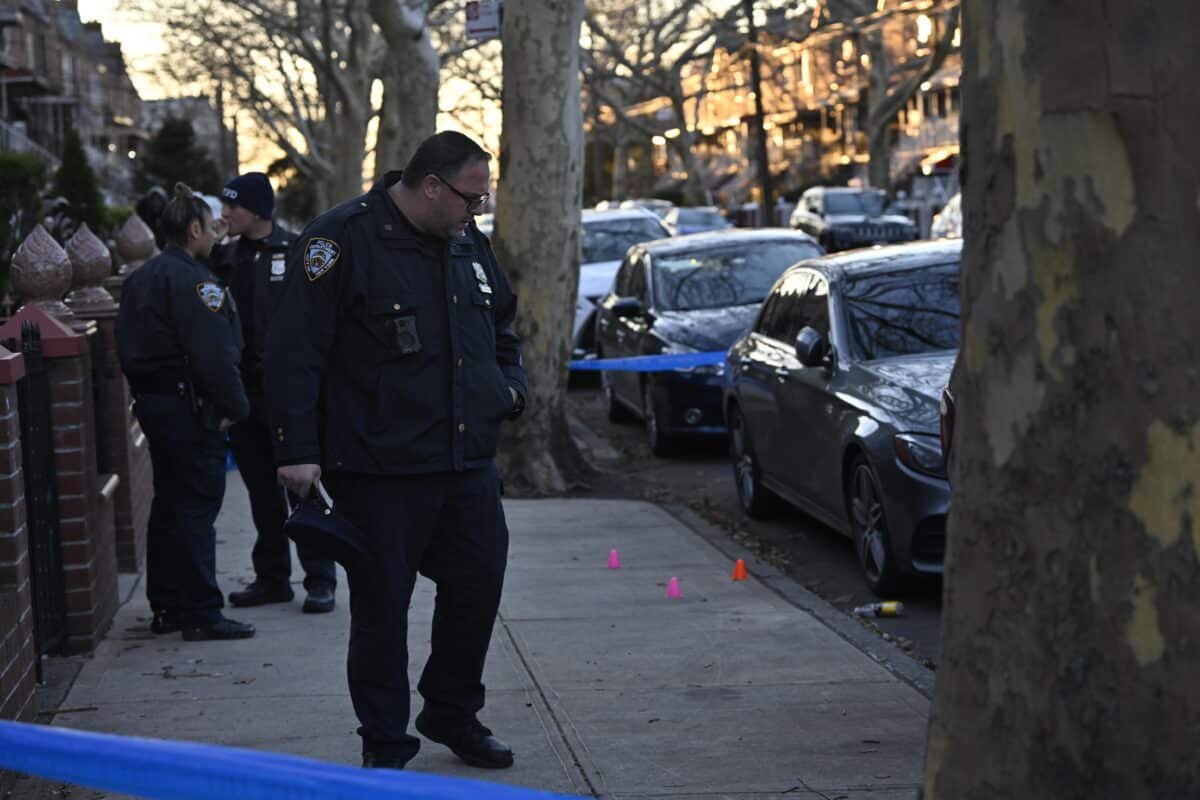 Police officer examines Brooklyn shooting scene