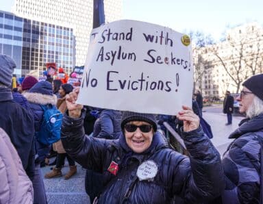 Protesters rally against the mayor's plan to evict migrants from shelters after 60 days.