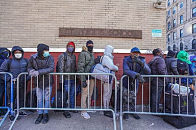 Migrants wait on line in East Village