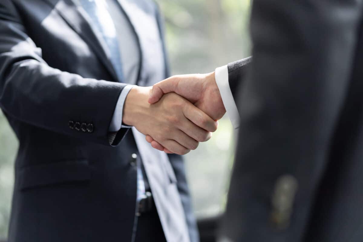 Japanese male businessmen shake hands with each other
