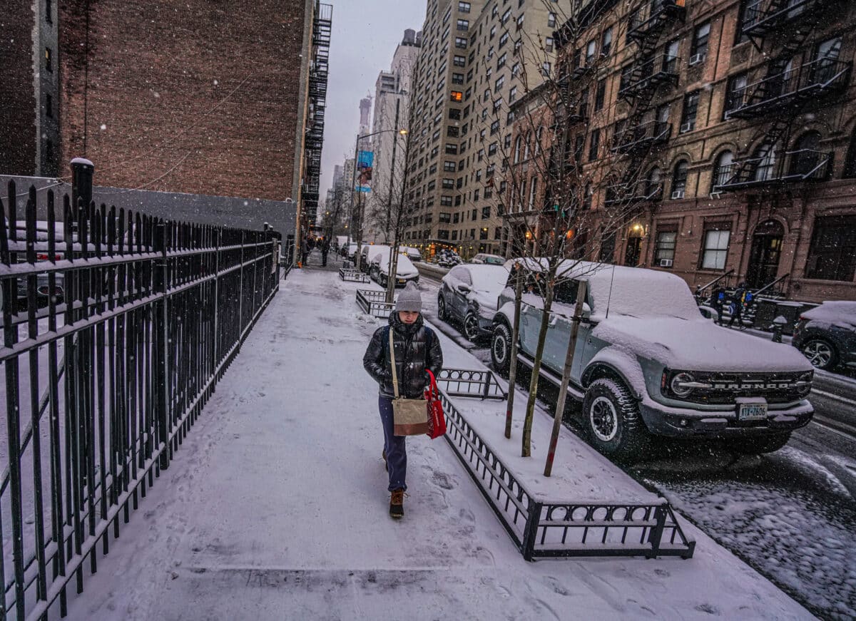 A New Yorker walks on snowy streets