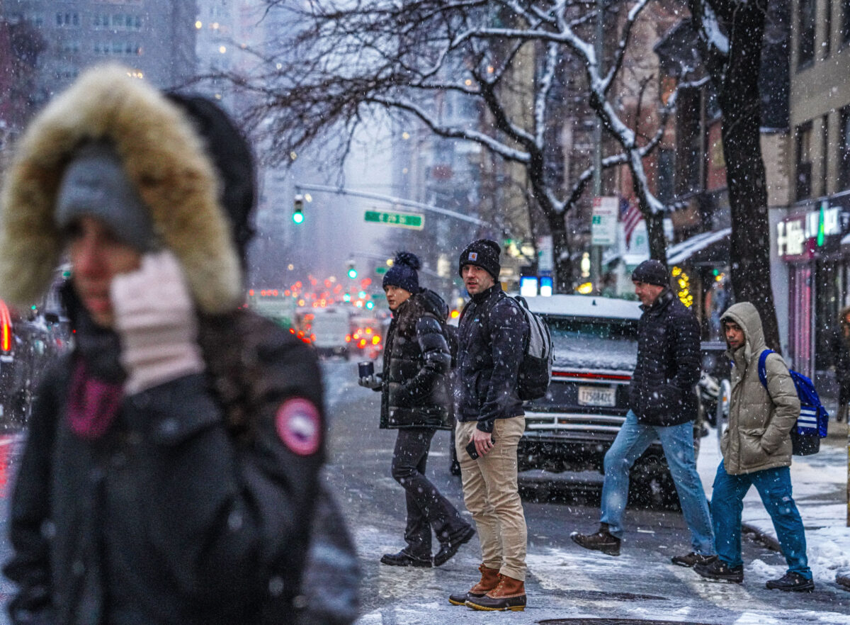 Commuters wait on snowy street