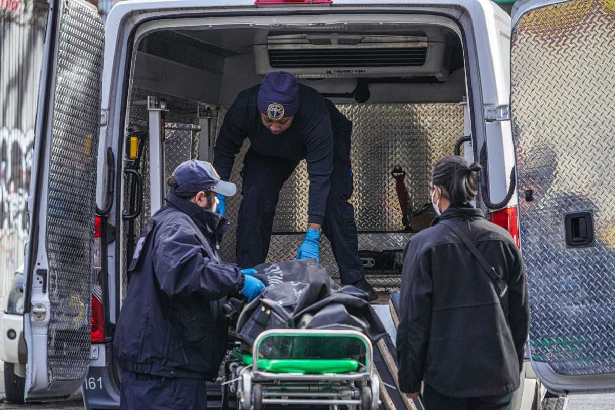 Medical examiner loads body into van in Queens
