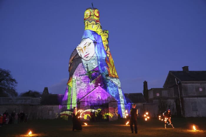Dancers perform in front of an image of St. Brigid