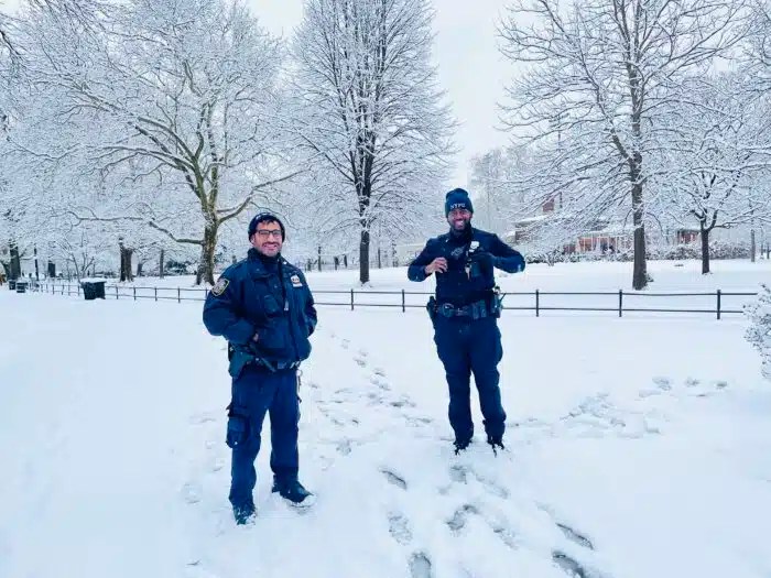 Two officers stand in snow in Brooklyn