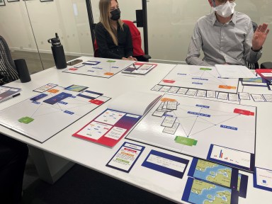 people demo a game on a table that is designed to improve disaster preparedness