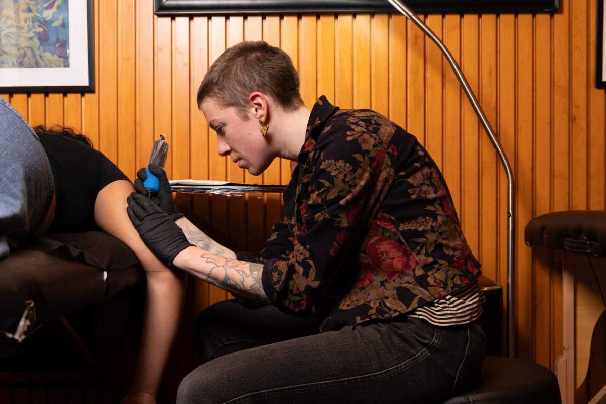 Liv Novotny, cofounder of Unscripted Ink, tattooing a customer.