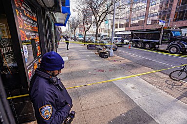 Officer looks at scene of Harlem double stabbing
