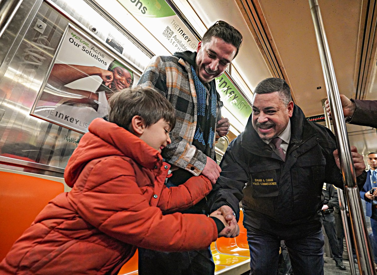 Police Commissioner Edward Caban speaks with NYC subway riders, shakes child's hand