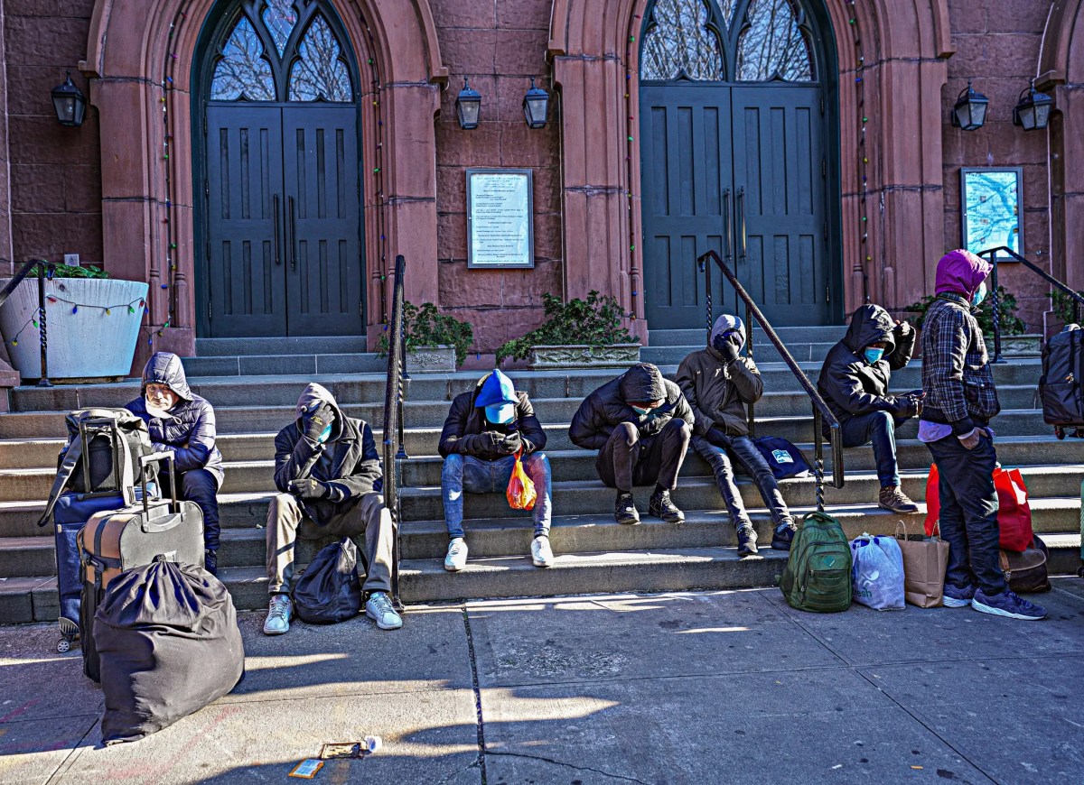 Migrants in migrant crisis sitting outside makeshift shelter