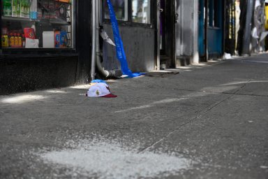 A hat lays on the sidewalk after an assault.