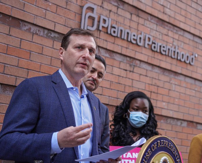 a group of people in front of a building discussing the Abortion Care Awareness Act