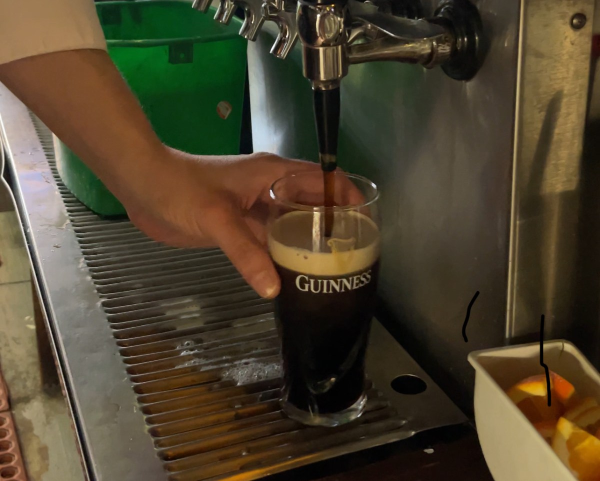 Pouring Guinness beer into glass