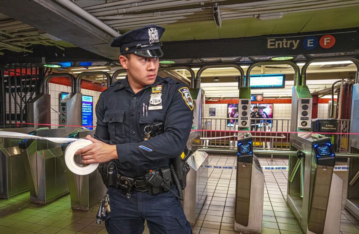 NYPD transit officer with police tape