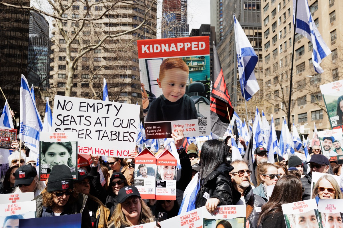 Hostage poster held up before crowd of people at rally in Manhattan