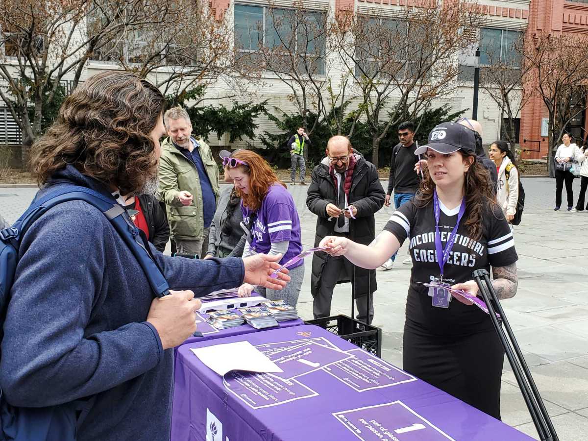 NYU students hand out glasses during solar eclipse