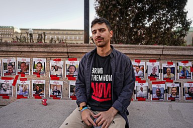 Columbia University student sits before hostage posters
