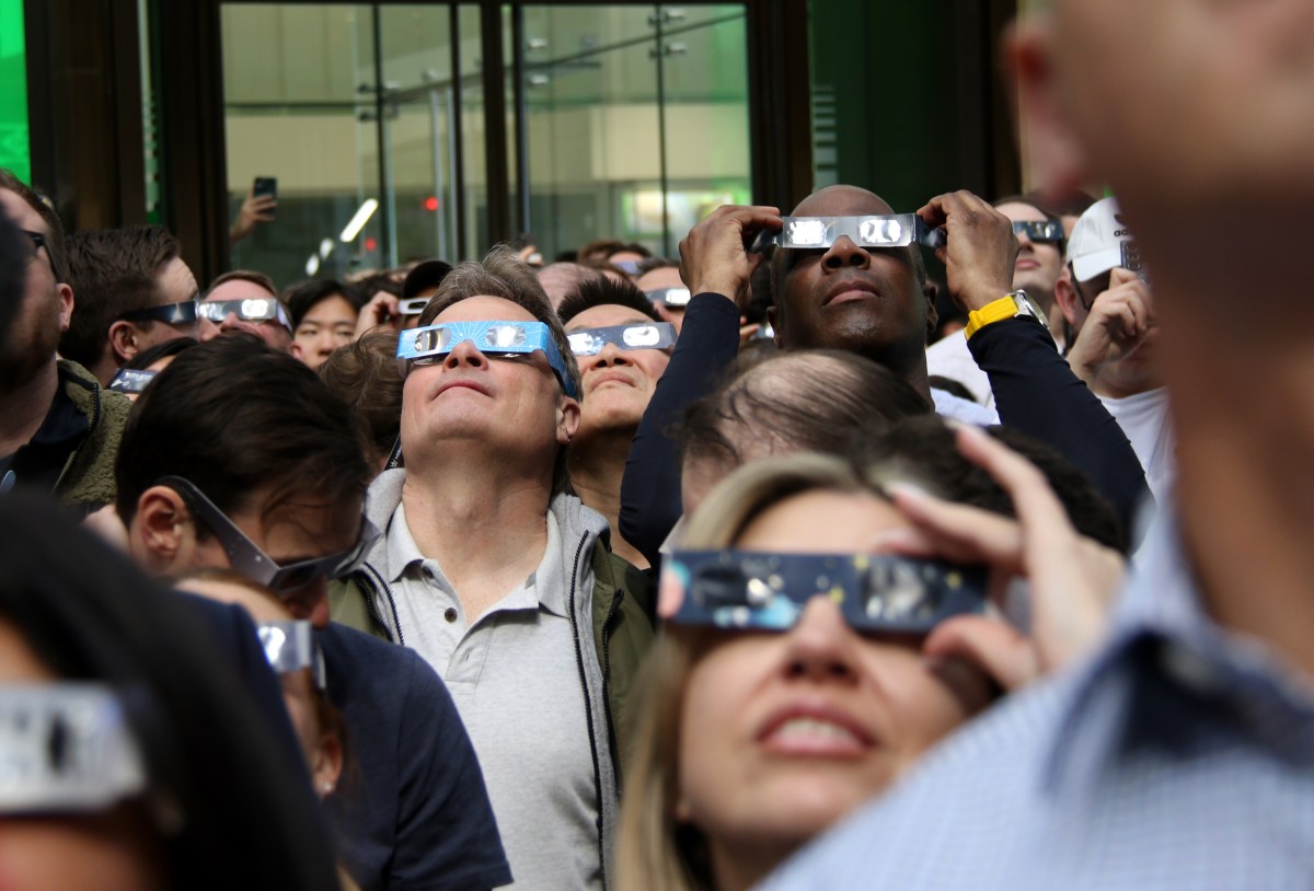 A crowd watches the eclipse at the corner of 42nd Street and Madison Avenue.