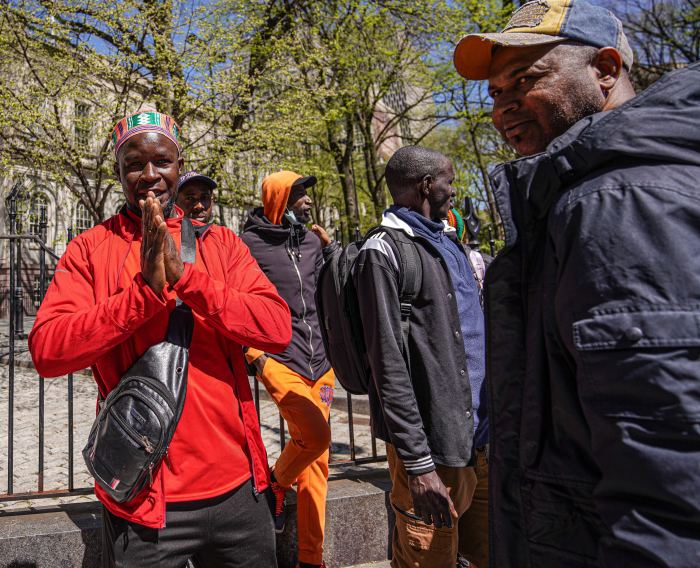 several migrants outside City Hall in NYC during the day