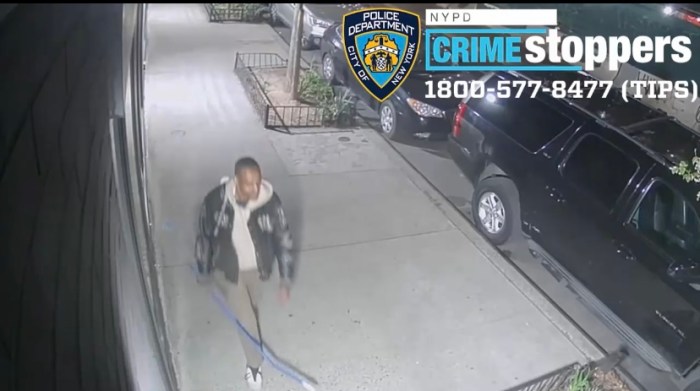 suspect wearing dark jacket holding a hockey stick on an East Village sidewalk