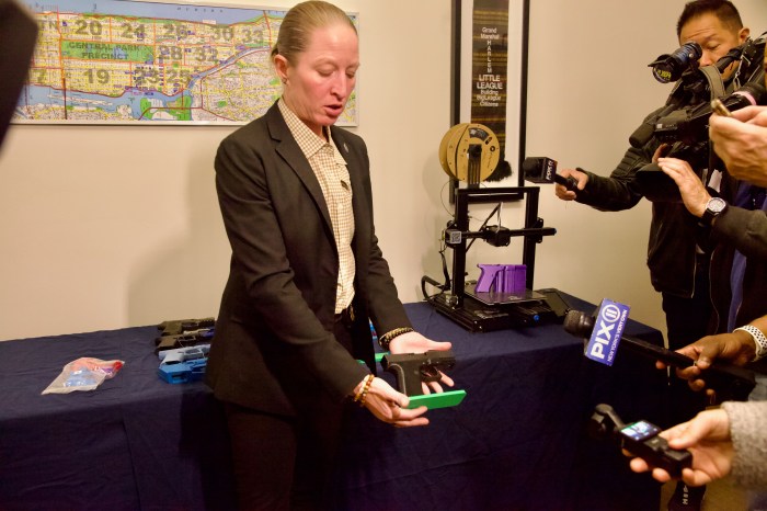 woman showcases a ghost gun during press conference with Manhattan DA Bragg about illegal guns including ghost guns