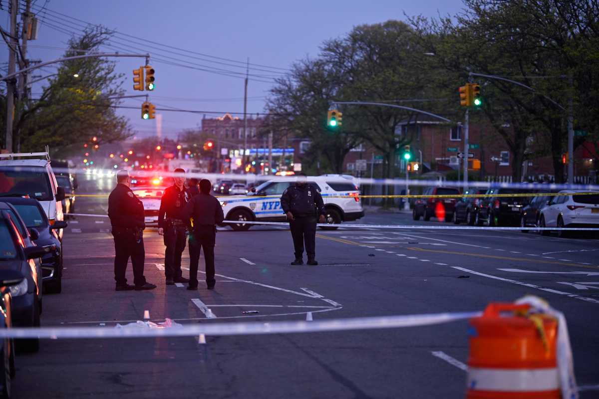 police investigating a shooting in Ozone Park in Queens with yellow caution tape around the scene
