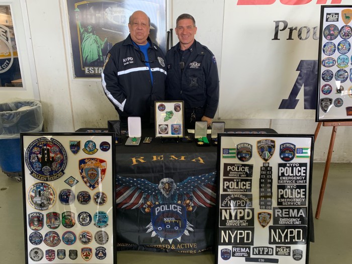 two police officers behind a table of medals and patches at Day of Remembrance for fallen NYPD officers