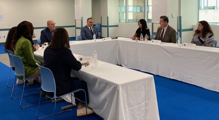 several people at a table, including Miguel Cardona, discussing student loan forgiveness