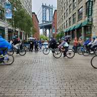 Five Boro Bike Tour bicyclists pedal along Brooklyn cobblestone street