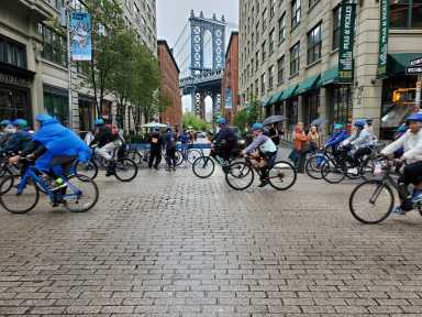 Five Boro Bike Tour bicyclists pedal along Brooklyn cobblestone street