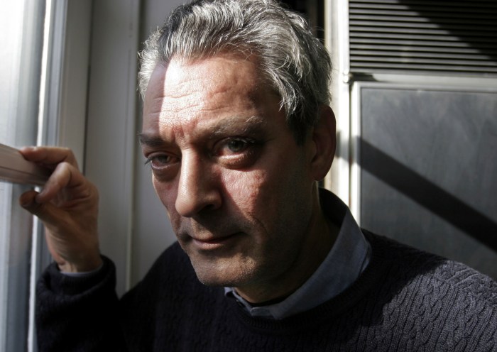 Writer Paul Auster looking out window with sun shining
