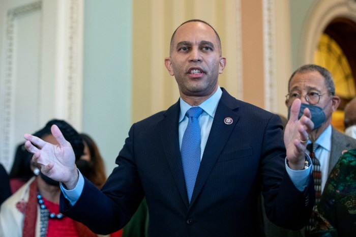 Hakeem Jeffries speaks at podium with hands stretched