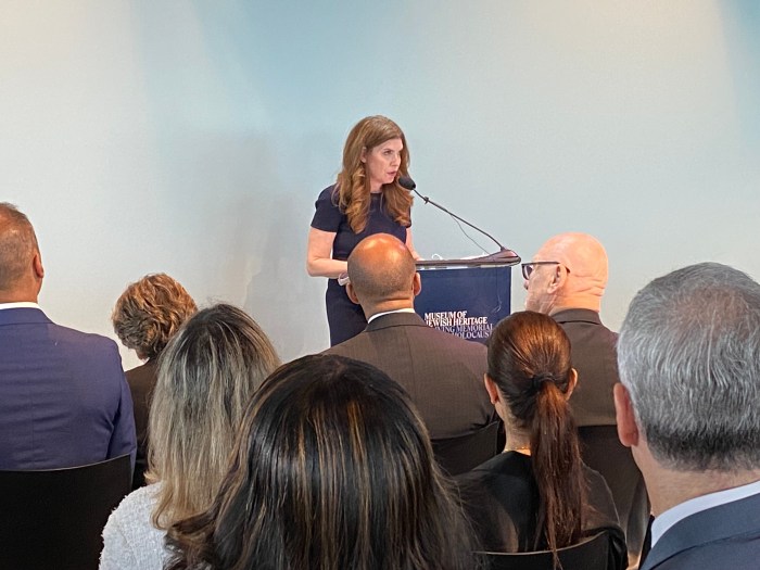 woman at a podium at the museum of Jewish Heritage