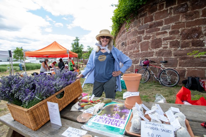 woman standing at a table at a lavender festival, one of the free outdoor events in Manhattan this summer
