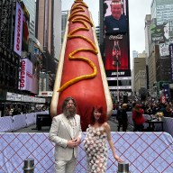 Artists stand in front of Hot Dog in the City sculpture
