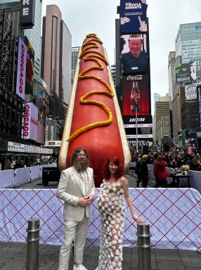 Artists stand in front of Hot Dog in the City sculpture