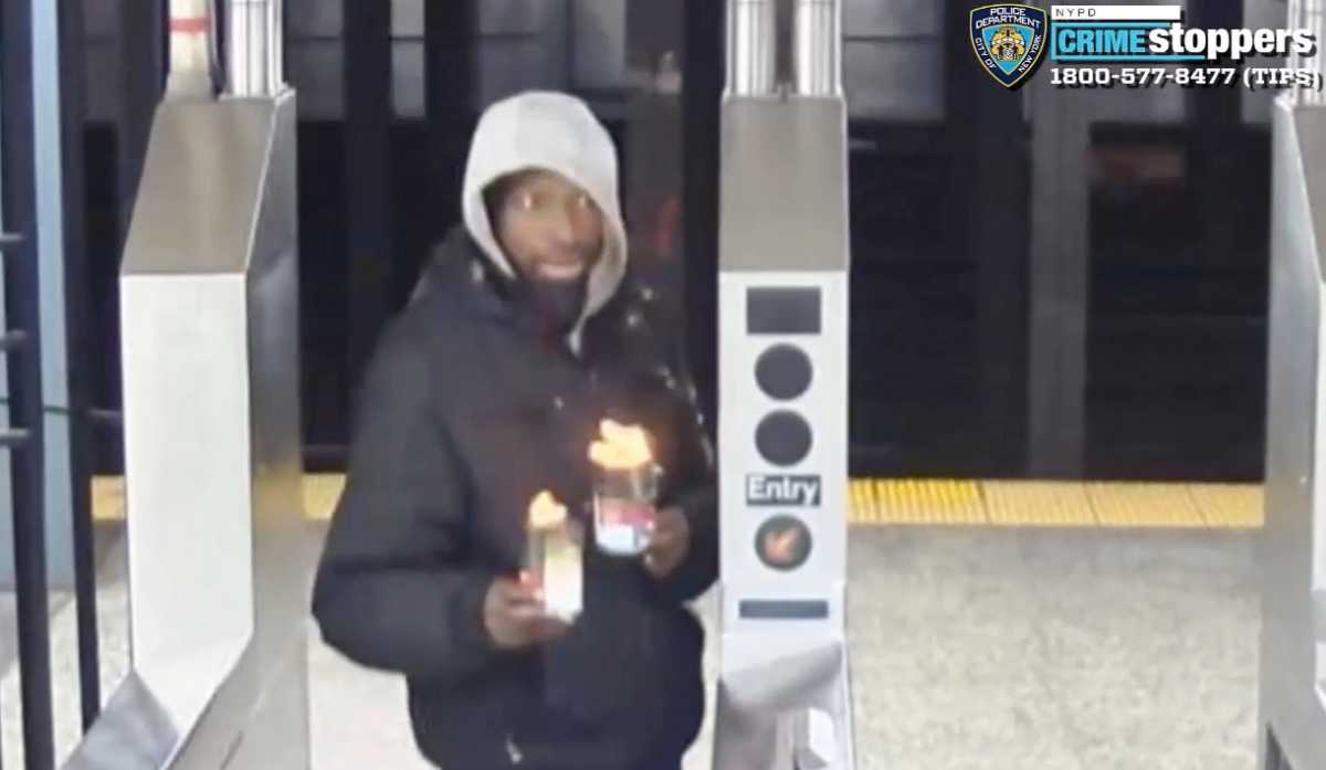 The suspect in two separate subway arson attacks, identified as Niles Taylor, is shown in this Feb. 5, 2024 security video still holding cups of flaming liquid while passing through the turnstile at the 28th Street station in Chelsea.