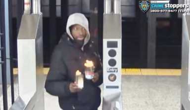 The suspect in two separate subway arson attacks, identified as Niles Taylor, is shown in this Feb. 5, 2024 security video still holding cups of flaming liquid while passing through the turnstile at the 28th Street station in Chelsea.