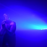 Art Bath performer Davone Tines bathed in blue light while performing