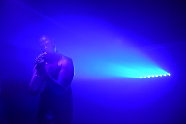 Art Bath performer Davone Tines bathed in blue light while performing