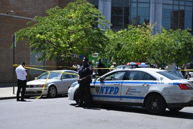 NYPD police car and officer investigating a shooting in the day time in Brooklyn