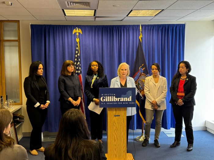 people on stage at a a podium, Kirsten Gillibrand in the middle discussing housing bill