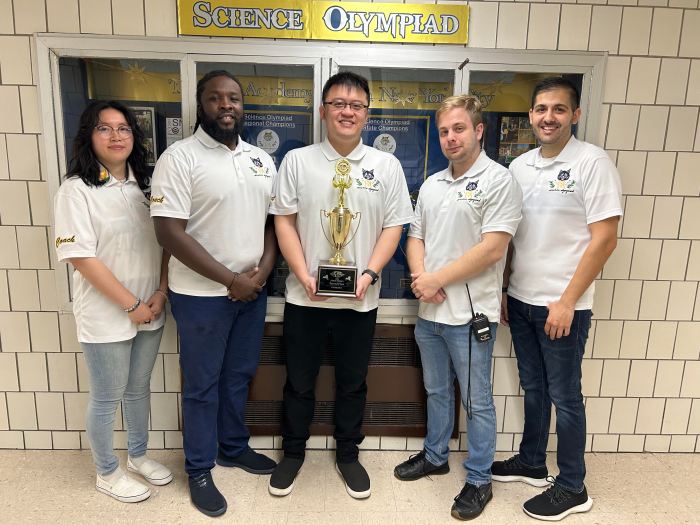 five adults from a Brooklyn school wearing white shirts standing in a school hallway