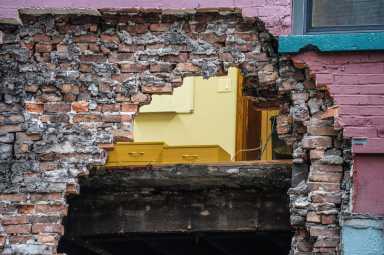 a NYC building facade with a massive hole in it