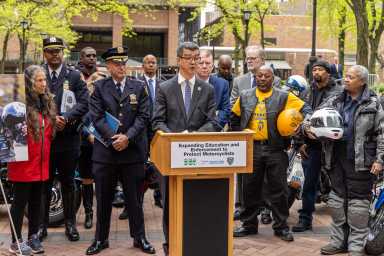 people at a podium in NYC discussing motorcycle safety