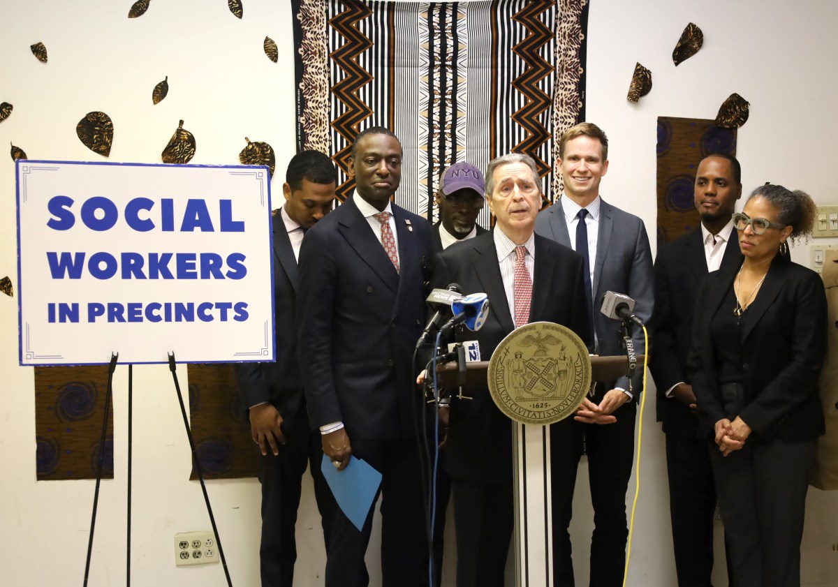 men in suits at a podium discussing social workers at NYPD police stations in NYC