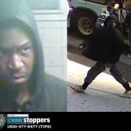 suspect wearing mostly black walking on a sidewalk wanted for assault in Manhattan