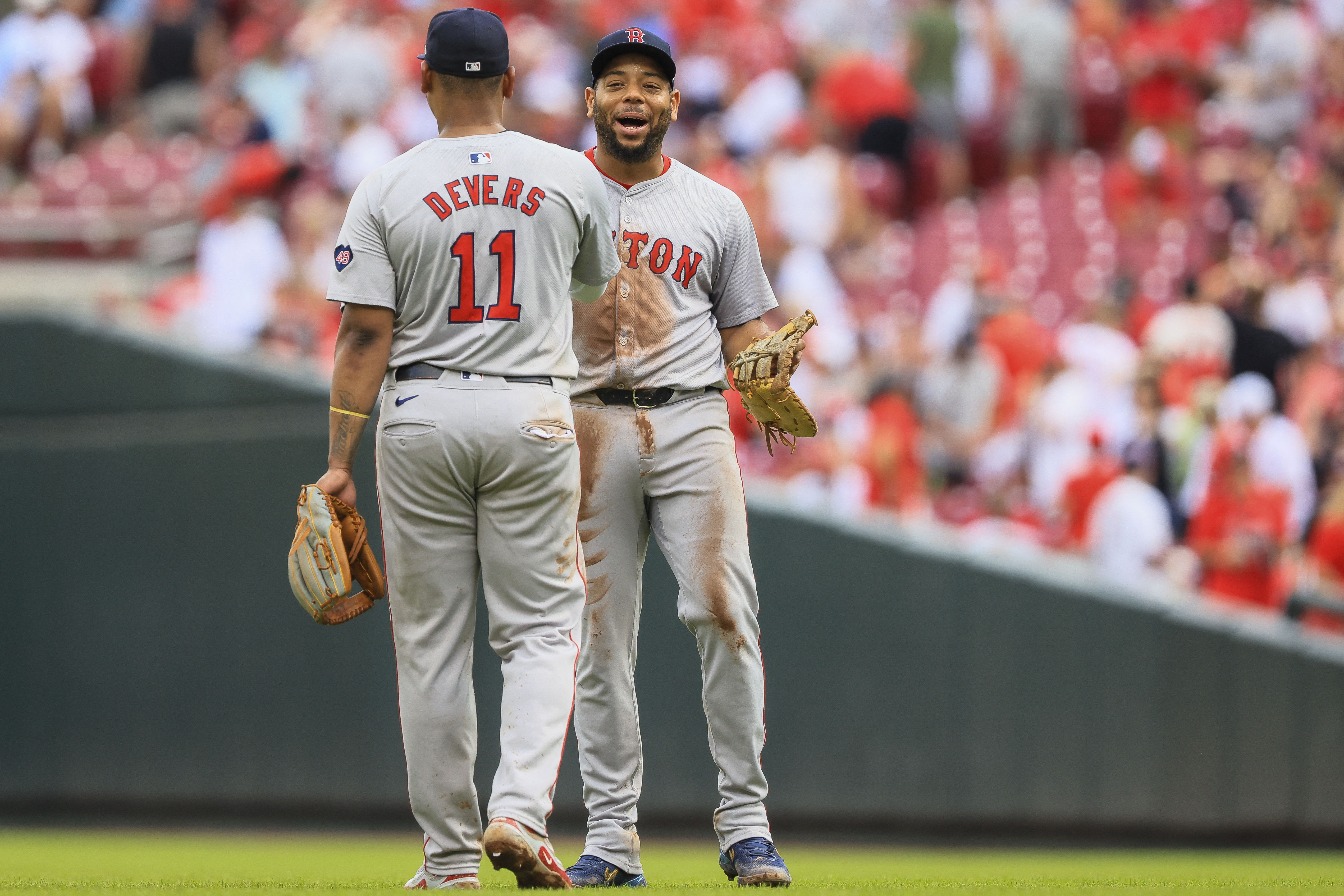 Boston Red Sox first baseman Dominic Smith reacts with third baseman Rafael Devers after the victory over the Cincinnati Reds at Great American Ball Park