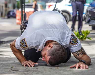 A police officer investigates a shooting scene