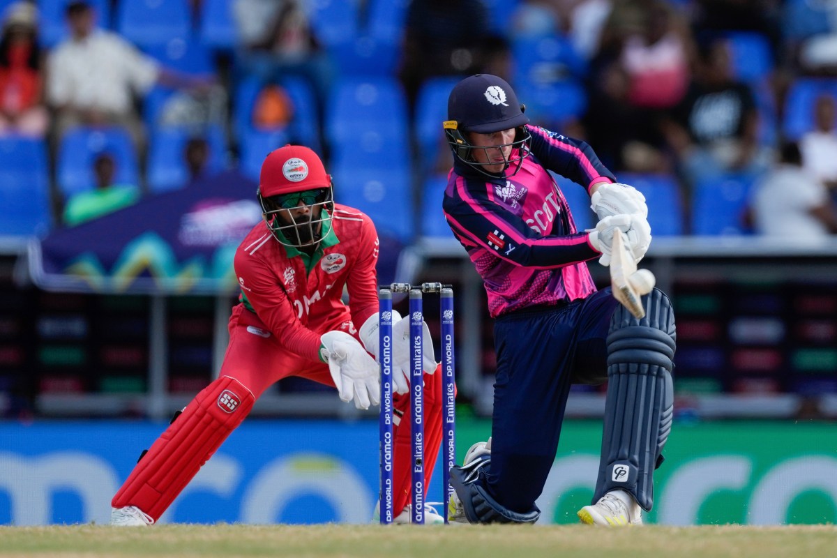 Scotland's Brandon McMullen plays a shot as Oman wicket keeper Pratik Athavale looks on during an ICC Men's T20 World Cup cricket match at Sir Vivian Richards Stadium in North Sound, Antigua and Barbuda, Sunday, June 9, 2024. (AP Photo/Ricardo Mazalan)